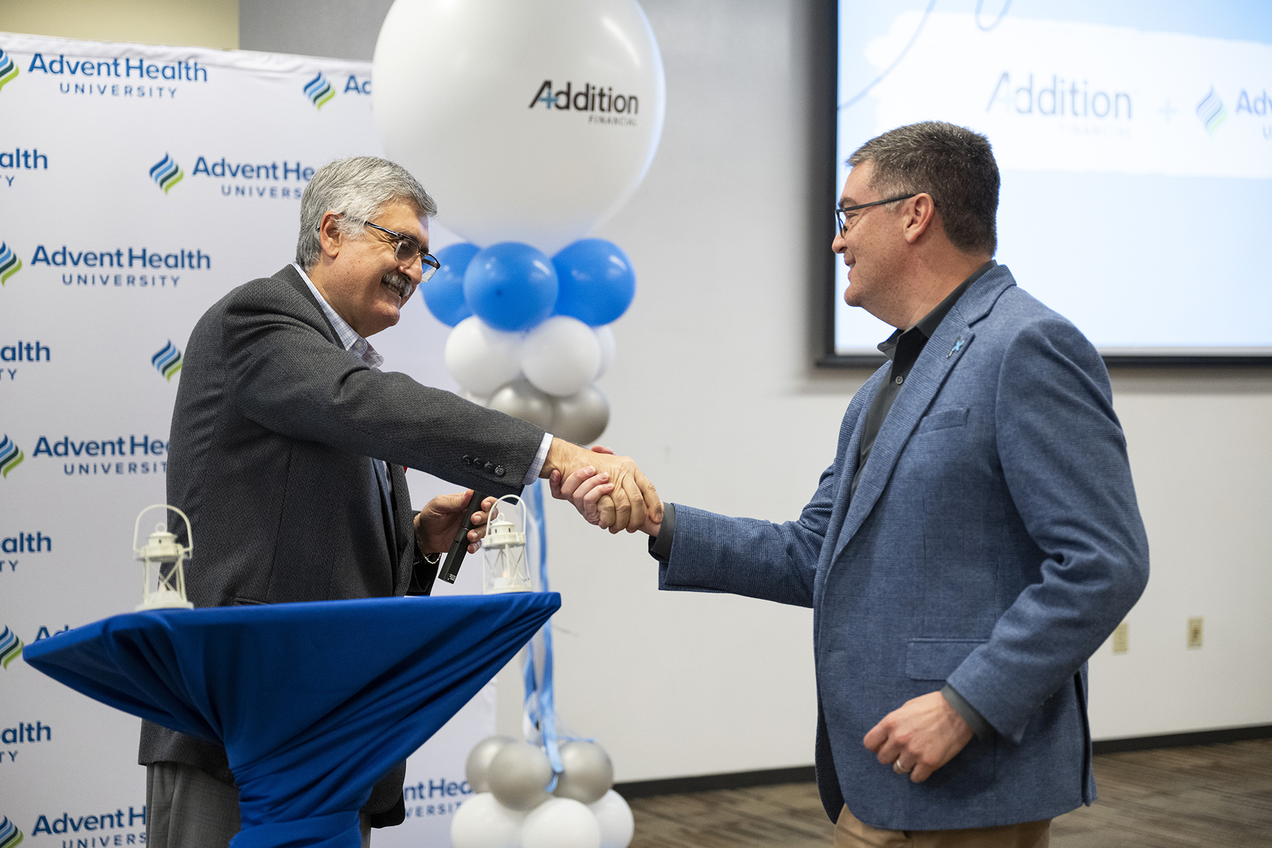 C. Josef Ghosn, EdD, FACHE, president of AdventHealth University, left, greets Kevin Miller, president and CEO of Addition Financial Credit Union, on Friday, Nov. 22.